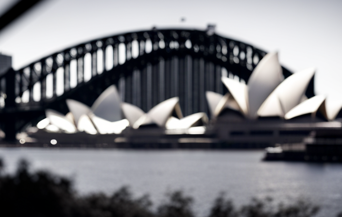 An image capturing the iconic Sydney Opera House and the majestic Harbour Bridge, with a bustling waterfront showcasing Circular Quay's Overseas Passenger Terminal, where magnificent cruise ships dock against the stunning city skyline